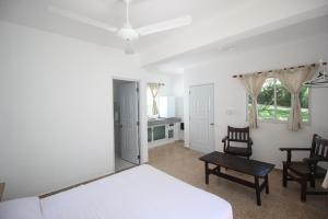 um quarto com uma cama, uma mesa e cadeiras em Bungalow 9 Cozy room at just steps from the beach and in town center em Sosúa