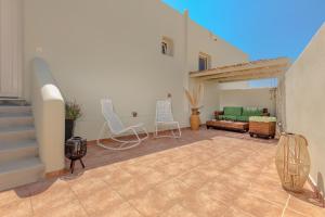 a patio with chairs and a couch in a house at Votrishouse in Fira