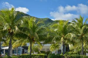 a group of palm trees in front of a building at Latitude - with private plunge pool in Rivière Noire