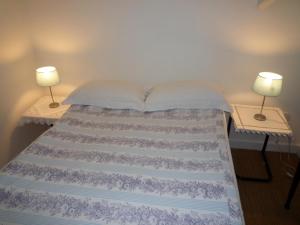 a bedroom with a bed with two lamps on tables at The Old Barn at Trymwood in Bristol