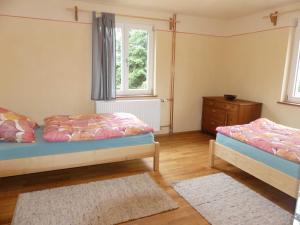 a bedroom with two beds and a dresser and a window at Fewo Im gruenen Eck 2 in Airlenbach
