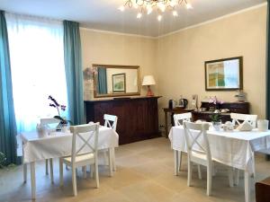a dining room with white tables and white chairs at A CASA DI TATI in Civitanova Marche