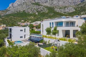 a white house with a mountain in the background at Villa Simon in Makarska