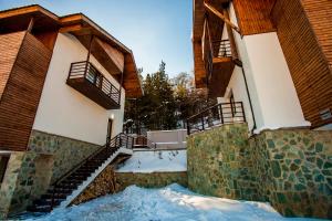 a building with snow on the ground in front of it at Crystal Hill Resort in Bakuriani