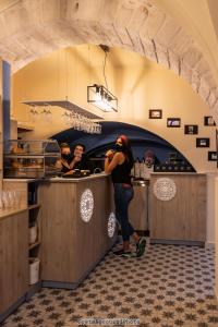 トゥーリにあるAlbergo Diffuso Dimora Rossiのレストランのカウンターに立つ女
