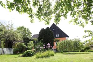 a house with a white fence and flowers in a yard at Ferienwohnung-Waldstrasse-mit-Garten-nur-50-Meter-vom-Wald-entfernt in Waldsassen