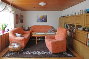 a living room with two chairs and a table at Ferienwohnung-Waldstrasse-mit-Garten-nur-50-Meter-vom-Wald-entfernt in Waldsassen