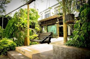 un banco de parque en un jardín con un edificio en Hotel Chicala salgar, en Puerto Salgar