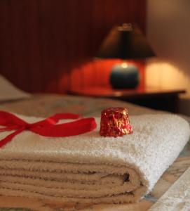 una pila de toallas con un arco rojo en una mesa en Alexandria Hotel en Pryluky