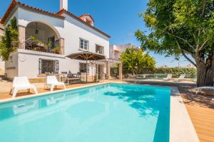 a villa with a swimming pool in front of a house at #049 Villa Lemon by Home Holidays in Albufeira