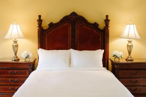 a bedroom with a large bed with two dressers and two lamps at Riverbend Inn & Vineyard in Niagara-on-the-Lake
