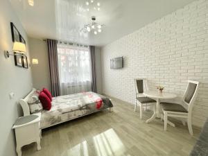 um quarto com uma cama e uma mesa com cadeiras em Apartment Studio PARIS 2 em Irpin
