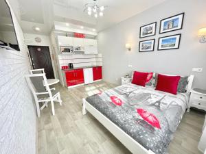 a bedroom with a bed with red pillows in it at Apartment Studio PARIS 2 in Irpin