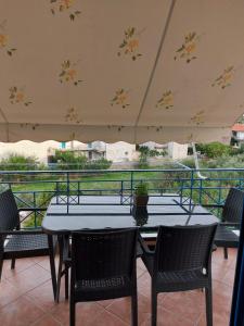 a patio with two tables and chairs and an umbrella at Matina Apartments Tyros in Tyros