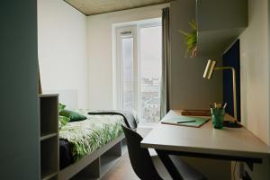 1 dormitorio con escritorio, 1 cama y ventana en Modern 3 Bedroom Apartments and Private Bedrooms at The Loom in Dublin, en Dublín