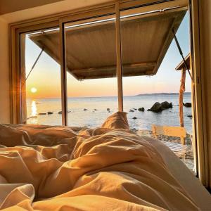 łóżko z oknem z widokiem na ocean w obiekcie lou cabanou w miejscowości Sainte-Maxime
