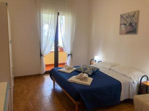 1 dormitorio con 1 cama con toallas en NaturAmare Apartments Palinuro, en Palinuro