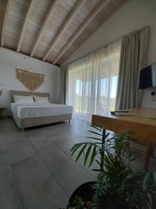 スカラ・エレソスにあるLithos Villasのベッドルーム1室(ベッド1台、大きな窓付)