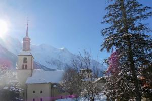 una chiesa nella neve con una montagna sullo sfondo di Flat Near The Slopes Chamonix Mont Blanc a Chamonix-Mont-Blanc