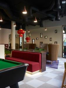 a billiard room with a red couch and a pool table at Spacious and Comfy Studios at Chapter Highbury I in London in London