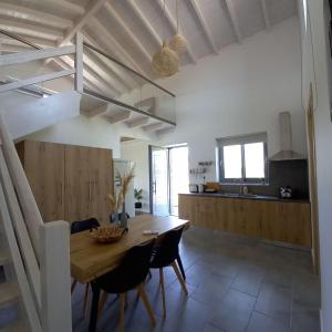 uma cozinha e sala de jantar com uma mesa de madeira e cadeiras em Lithos Villas em Skala Eresou