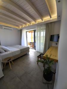 sypialnia z łóżkiem i biurkiem w pokoju w obiekcie Lithos Villas w mieście Skala Eresou