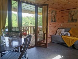 sala de estar con mesa y sofá en Domaine des Z'Ailés en Saint-Florent-des-Bois