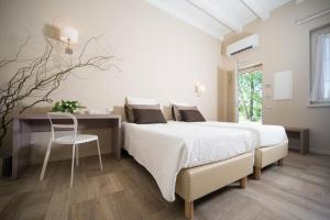 a white bedroom with a bed and a desk at Agriturismo La Galizia in Cuggiono +43 photos