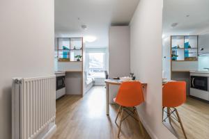 a kitchen with two orange chairs and a table at For Students Only Stoneworks in Brighton in Brighton & Hove