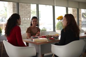 a group of women sitting around a table eating food at For Students Only Stoneworks in Brighton in Brighton & Hove