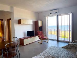 a living room with a television and a room with a balcony at Amphora Vibes in Vama Veche