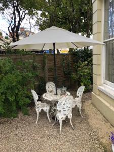 a table and chairs under a white umbrella at Lovely 3-Bed House in Cheltenham in Cheltenham