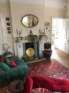 a living room with a green couch and a fireplace at 2 Bed House - Sleeps 6 - Garden Pets Parking in Cheltenham