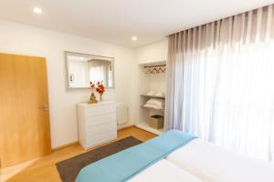 1 dormitorio con cama y ventana en Apartamento Mar & Sol, en Póvoa de Varzim