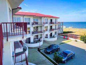 two cars parked in a parking lot in front of a building at Amphora Vibes in Vama Veche