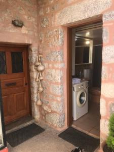 a door leading to a kitchen with a washing machine at Aroma Avlis Apartment in Areopoli