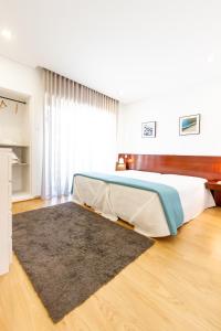 - une chambre avec un lit et un tapis au sol dans l'établissement Apartamento Mar & Sol, à Póvoa de Varzim