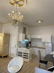 una cucina con tavolo e lampadario pendente di Studio du Maire Maison de L'Église du Couvent a Narbonne