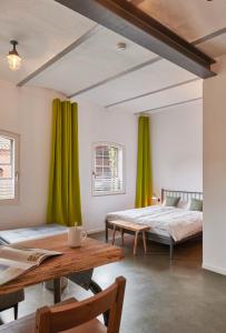 two beds in a room with green curtains at re~barn - Modern Country Stay in Essel