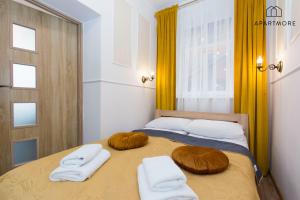 a bedroom with a bed with two towels on it at Old Town by Apartmore in Gdańsk