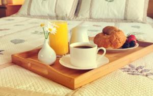 ein Tablett mit einer Tasse Kaffee und einem Teller Essen auf dem Bett in der Unterkunft Nyvky like Home in Kiew