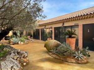 une maison avec beaucoup de plantes dans la cour dans l'établissement HOTEL NATURE LE LOFT, à Pierrelatte