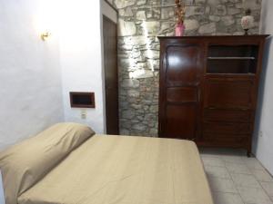 1 dormitorio con cama y pared de piedra en Chibau Berria-Aperçu mer et montagne à côté de la plage en Saint-Jean-de-Luz