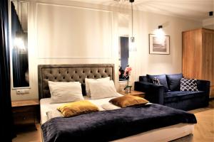 Un dormitorio con una cama grande y un sofá. en Apartamenty Royal Maris 1 - najlepsza lokalizacja w Ustce, blisko plaży i portu, bezpłatny parking, ścisłe centrum, en Ustka