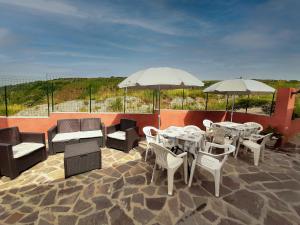 een patio met tafels, stoelen en parasols bij Locanda Adele in Parghelia