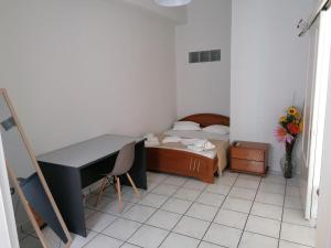 una camera con una scrivania e un letto. di ANTONIS ROOMS 2 a Ermoupoli