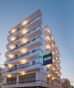 Un grand bâtiment blanc avec un panneau devant. dans l'établissement Hotel Base - Adults Only, à Sant Antoni de Portmany