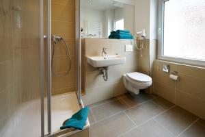 a bathroom with a shower and a sink and a toilet at Hotel im Kupferkessel in Cologne