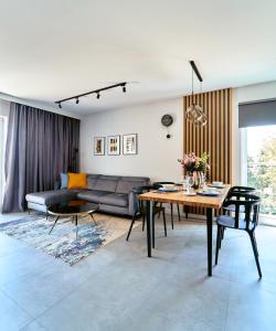 een woonkamer met een bank en een tafel bij LAGUNA Apartament Polanica Residence 36 LUX in Polanica-Zdrój