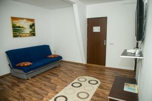 a living room with a blue couch and a wooden floor at Vile Mamaia Nord in Mamaia Sat/Năvodari